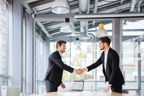 Two happy businessmen standing and shaking hands on business meeting by vadymvdrobot. Two happy successful young businessmen standing and shaking hands on business meeting#shaking, #hands, #standing, #happy Circle Logos Inspiration, Shaking Hands, Architecture People, Corporate Headshots, Business Photos, Business Meeting, Abstract Photos, Modern Graphic Design, Business Logo Design