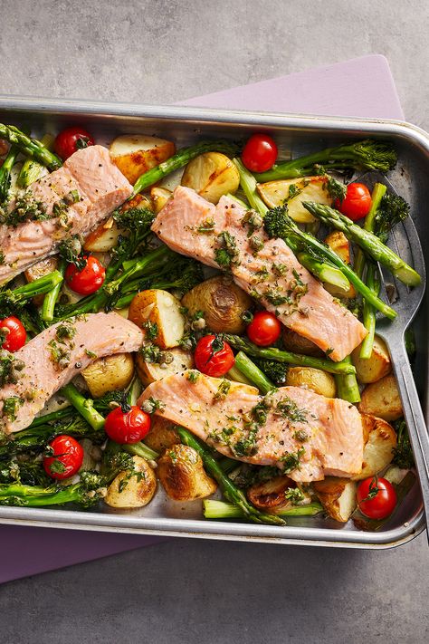 Four salmon fillets in a roasting tray on top of new potatoes, tomatoes and asparagus. Georgina Hayden, Traybake Dinner, Salmon Tray Bake, Oven Baked Salmon Recipes, Tartiflette Recipe, Low Carb Potatoes, Lemon Pepper Salmon, Nadiya Hussain, Oven Baked Salmon