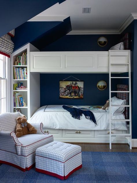 Navy blue boys' bedroom features built in bunk beds lined with red and blue plaid headboards finished with wainscot trim situated next to a built in bookcase. Nautical Mirrors, Traditional Kids Bedroom, Blue Boys Bedroom, Bunk Beds Built In, Boy Rooms, Built In Bed, Built In Bunks, Bunk Rooms, Kid Rooms