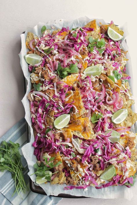 Pulled pork nachos are a crowd-pleaser! The tangy, acidic bite from the coleslaw and marinated onions packs a nice punch with the pulled pork. Make this for your next party appetizer, or as a Saturday night dinner. #nachos #pulledpork #appetizer #fingerfoods Dinner Nachos, Crowd Pleaser Appetizers, Marinated Onions, Smoked Salmon Canapes, Saturday Night Dinner, Happy Hour Appetizers, Pulled Pork Nachos, Greek Appetizers, Cilantro Lime Slaw