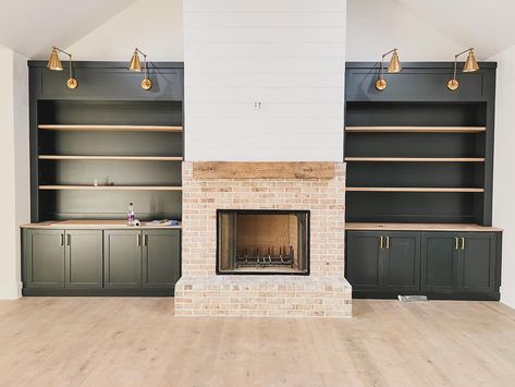 Sometimes a last minute decision is actually a great thing…these built in shelves were going to be white. We decided because most of the house was white inside (for now), it would be fun to make these stand out. And with the addition of white oak shelves, we love the way they turned out! Did you make any last minute changes on your home? Paint color is Sherwin Williams Iron Ore. #livingroomideas #livingroominspiration #livingroomdesign #builtins #builtinshelves #paintedcabinets #ironore #... White Oak Shelves, Sherwin Williams Iron Ore, Basement Fireplace, Home Paint Color, Home Paint, Oak Shelves, Iron Ore, Painting Trim, Built In Cabinets