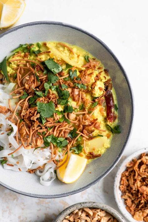 Kaukswe is a Burmese dish with a delicious yellow curry served with rice noodles and an assortment of toppings to add to each serving. It's easy to make, pantry friendly, and addictively delicious! The recipe is gluten free if all toppings chosen are gluten free. Also spelled khao soi or khow suey. #veganentree #veganmain #glutenfreevegan #burmese #curry #vegancurry #tofucurry #ricenoodles #noodles Khow Suey Recipe, Khao Suey, Turmeric Curry, Tofu Rice, Burmese Food, Tofu Curry, Khao Soi, Yellow Curry, Easy Curry