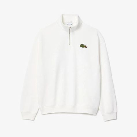 The Lacoste Unisex Quarter Zip Loose Fit Sweatshirt is a stylish and comfortable piece designed for versatility and ease. Made from soft organic cotton, this sweatshirt offers a relaxed, loose fit for a casual and contemporary silhouette. It features a quarter-zip closure with a stand-up collar, allowing for adjustable coverage and a modern look. The iconic Lacoste crocodile logo is subtly embroidered on the chest, adding a touch of brand heritage. Ribbed cuffs and hem provide a snug fit, while Relaxed Chic, Crocodile Logo, Sweatshirt White, Comfy Sweatshirt, Workout Sweatshirt, White Sweatshirt, Relaxed Style, 1/4 Zip, Fleece Fabric