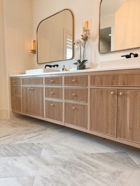 Transform your bathroom into a spa oasis with stunning white oak cabinets with reeded fronts and brass knobs. The wood grain texture adds natural warmth and depth while the reeded detailing provides a subtle touch of visual interest. #bathroomcabinetry #bathroomdesign #interiordesign Reed Front Cabinet, Kitchen With Bamboo Cabinets, Reed Cabinet Door, Reeded Vanity Bathroom, Reeded Cabinets Bathroom, Reeded Wood Kitchen Island, Reeded Bathroom Vanity, Fluted Cabinet Kitchen, Reeded Cabinet Door