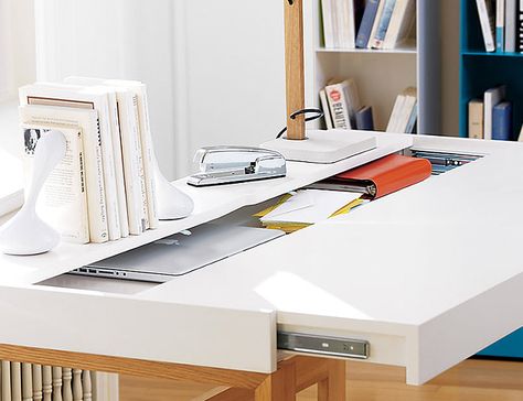 The lacquered white 57″ wide by 24″ deep surface sitting on a solid white oak stretcher base appears a traditional desk to most. A gentle pull on its top reveals nine square feet of stash space to quickly conceal books, gadgets and other office detritus- hidden cutouts for keeping wires neatly in line. Mother Teresa said “Peace begins with a smile”, but a clean work environment is a close second, right? Dream Desk, Office Furniture Modern, Diy Desk, Modern Desk, Desk Design, Modern Table Lamp, Table Storage, Home Office Design, Modern Table