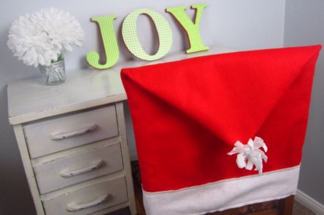 Spice up your dining room decor this season with homemade santa hat chair covers. Sew together these easy holiday decorations with felt and thread. Diy Santa Hat, Fabric Kitchen Chairs, Christmas Headbands, Christmas Sofa, Kitchen Chair Covers, Chair Back Covers, Christmas Chair Covers, Christmas Chair, Diy Santa