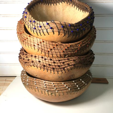 My mother made these cute 8 -9 inch diameter, handmade pine needle embellished gourd baskets . They are 4 inches tall.  She sources the cured, barrel gourds from Fallbrook, California and cleans, cuts and polishes them.  It is always a surprise what the gourd will look like until it is cleaned, and sometimes you get a gourd with a lot of character. She then coils pine needles around the gourd base using Irish waxed linen thread.  She adds the colored beads to enhance the personality of each basket. They have a protective wax coating on the outside.  The pine needles are collected from  Ponderosa Pine trees in our neighborhood in San Diego, CA. Pine needle basketry is truly a labor of love.  Each basket took 3 days to make.  My mother loves making these and is excited to find people who wil Gourd Basket, Gourd Baskets, Pottery Corner, Gourd Bowls, Gourd Carving, Fallbrook California, Pine Needle Crafts, Contemporary Baskets, Bushel Baskets