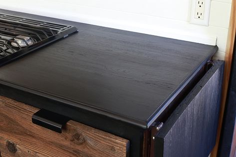 Considering adding black kitchen countertops to your home? Come see how we updated butcher block countertops for a rustic modern vibe in our RV. MountainModernLife.com #rvrenovation #rvremodel #rvkitchen #blackcounters #blackcountertops #rusticmodern #rusticmodernkitchen #mountainmodern #diycounters #tinykitchen #tinyhome #camperremodel #mountainmodernlife Black Stain Butcher Block Countertops, Ebony Stained Butcher Block Countertops, Black Stained Butcher Block Countertops, Black Wood Countertops, Van Countertops, Ebony Butcher Block Countertops, Gray Stained Butcher Block Countertops, Dark Butcher Block Countertops Kitchen, Black Butcher Block Countertops