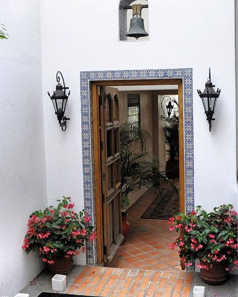 A very classic home style doorway. The bell, the light fixtures and the flooring are all complemented by the decorative Mexican tiles around the door frame. Spanish Style Front Door, Moroccan Doors, New Mexico Homes, Barn Living, European Style Homes, Mexican Home Decor, Mexican Home, Mediterranean Home Decor, Spanish Style Home