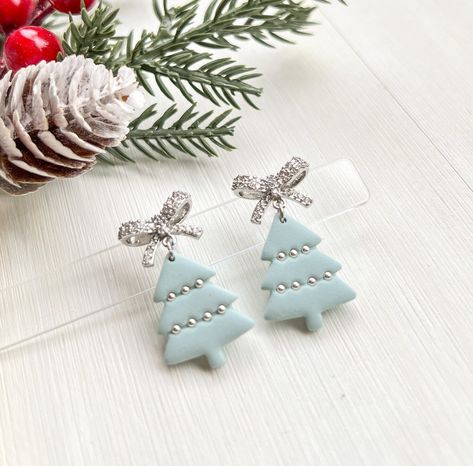 🌿 An unique handmade polymer clay Christmas tree teamed with rhodium plated ribbon with rhinestone. It's elegant and simple! Easy to match your Christmas outfit! ✏️ It's 3cm long and lightweight! You can choose your earrings closure - Invisible clip on or Rhodium Plated Post! ✌🏻Sold as a PAIR 💖 It is the most comfortable clip on earrings, it had been tested on myself, my daughter and my friend! They are secure and comfortable! If you have non-pierced ears like us, you will fall in love with t Polymer Earrings Christmas, Polymer Clay Earrings Inspiration, Christmas Clay Jewelry, Polymer Clay Christmas Tree Earrings, Polymer Christmas Earrings, Winter Polymer Clay Earrings, Christmas Earrings Polymer Clay, Easy Polymer Clay Earrings, Clay Earring Designs