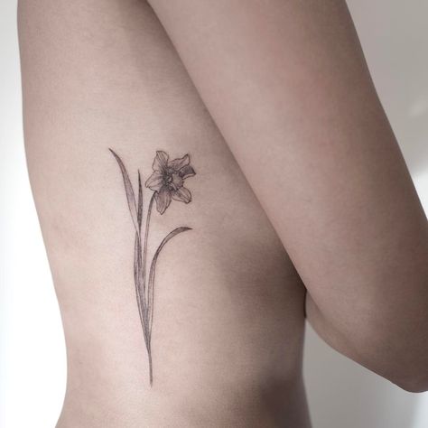 Delicate black daffodil tattoo along the rib cage. #daffodil #flowertattoo Small Daffodil Tattoo, Wildflowers Tattoo, Tattoo Son, Tattoo For Boyfriend, Daffodil Tattoo, Lily Tattoo, 1 Tattoo, Rib Tattoo, Friend Tattoos