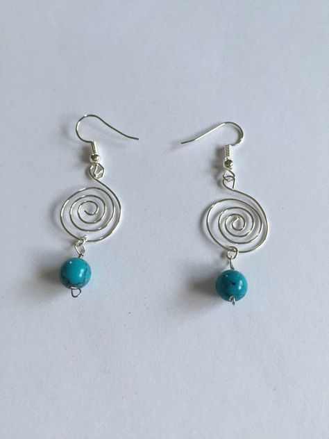 Silver plated wire spiral dangling earrings with glass torquiose style beads. The earring hooks are silver plated and nickel and lead free. The silver plated wire is tarnish resistant and nickel and lead free. Hand crafted in Hawaii. A great gift for a special loved one! Silver Wire Earrings, Diy Wire Earrings, Homemade Earrings, Wire Wrap Jewelry Designs, Bijoux Fil Aluminium, Swirl Earrings, Diy Wire Jewelry, Spiral Earrings, Handmade Wire Jewelry