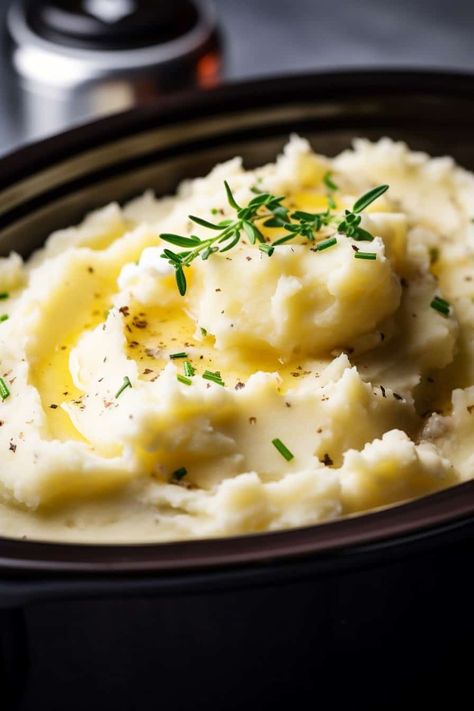 A close-up of slow cooker mashed potatoes in a crockpot, topped with a pat of butter and fresh thyme, showing a smooth and creamy texture with herbs sprinkled on top. Mashed Potatoes Food Photography, Thanksgiving Crockpot Mashed Potatoes, Thanksgiving Mashed Potatoes Recipe Crock Pot, How To Make Mashed Potatoes In Crock Pot, Crockpot Russet Mashed Potatoes, Slow Cooker Garlic Mashed Potatoes, Mashed Potatoes In A Crockpot, Crockpot Mash Potatoes, Crockpot Mashed Potatoes Recipes