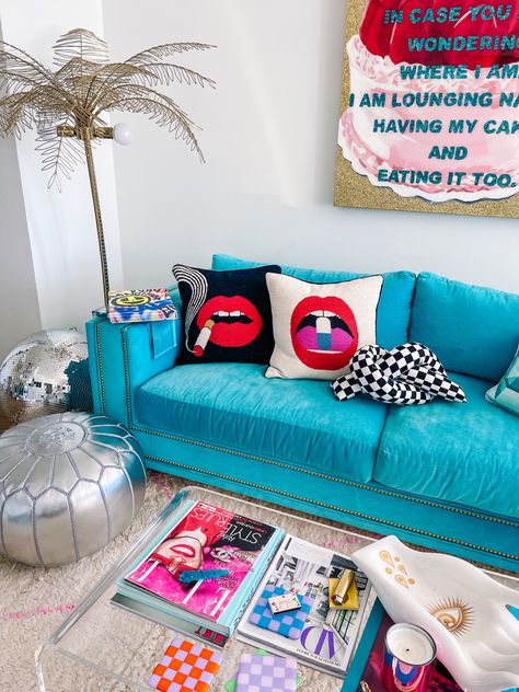 Blue velvet couch cake painting Ashley Longshore, acrylic coffee table, fashion magazines and coffee table books Colorful Studio Apartment, Pop Art Bedroom, Preppy Living Room, Colorful Studio, Apartment Styling, Living Room Colorful, College House Decor, Miami Decor, Colorful Apartment