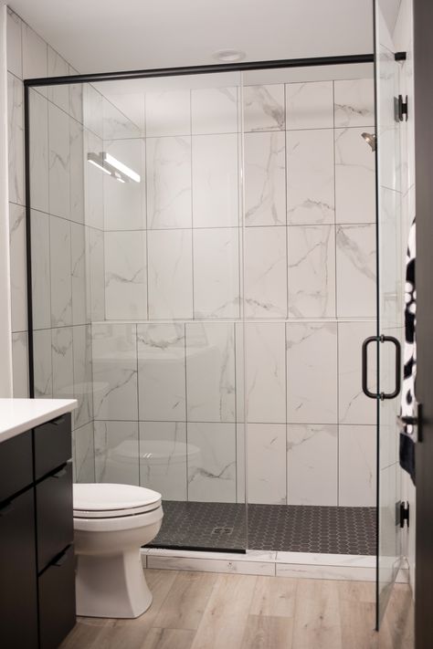 walk in shower with white marble tile walls and black tile floor Black Shower Floor White Walls, Black Shower Floor Tile White Walls, Marble Shower With Black Floor, White Tile Shower With Black Floor, Walk In Shower Marble, Marble Shower Ideas, Black And White Shower Tile Ideas, Marble Shower Bathroom, Shower Marble Tile