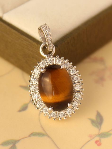 $35.00 Presenting You a Beautiful Tiger Eye Pendant Accented with Zircons In Oval Shape The Sheen in this tiger Eye Cabochon is remarkable and shifts while rotating Gem. Combine it with Multiple Minimal Charm as Centre Pendant. Perfect Gift for anniversary Birthday wedding or even valentine. #Bohemianjewelry #bohemianpendant #chainpendant #evileyeprotection #protectingstone #healingstone #halonecklace #tigereyecabochon #charm #layeringnecklace #sterlingsilver #bohoandhippie #bohostyle #boho Amethyst Earrings Studs, Beautiful Tiger, Unique Pendant Necklace, Amethyst Studs, Tiger Eye Jewelry, Gift For Anniversary, Halo Necklace, Tigers Eye Necklace, Indian Jewellery Design Earrings