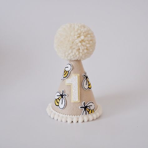 Say HELLO to our new addition - Boho Bee Day Party Hat! With cute little feature bees, this hat is perfect for those bee day themed cake smash's or photoshoots! Premium quality, handmade and 100% original design from Our Little Deer DETAILS ♕  1 x 100% Merino Wool Felt Party Hat. Finished with feature bees, mini pom trim, number of choice and wool Pom.  (any number available, not just for 1st Birthdays. Please select number) Elastic comes attached to wear around back of head. ♕ Matching "One" ca Happy Bee Day First Birthdays, First Bee Day Party, Birthday Hat Png, Bee Day Party, Boho Bee, Hat Birthday Party, Bee Sweet, Mini Pom, Hat Cake