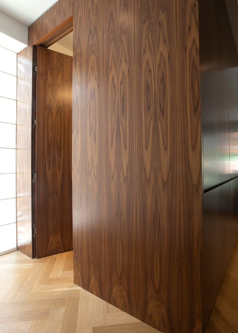 Does your door ruin the sleek look of the wall? Bookmatched walnut paneling conceals the flush powder room door. We decided to install a standard lever handset for fear that guests wouldn't find the powder room with no visible hardware on the door. 

#HomeBuilder #luxuryhomes #Toronto #renovations #remodeling #HomeAddition #construction #wholehomerenovation Century Home Renovation, Modern English Interior, Jib Doors, Powder Room Door, Walnut Paneling, Bold Front Door, Hidden Doors In Walls, Cali House, Wood Panneling