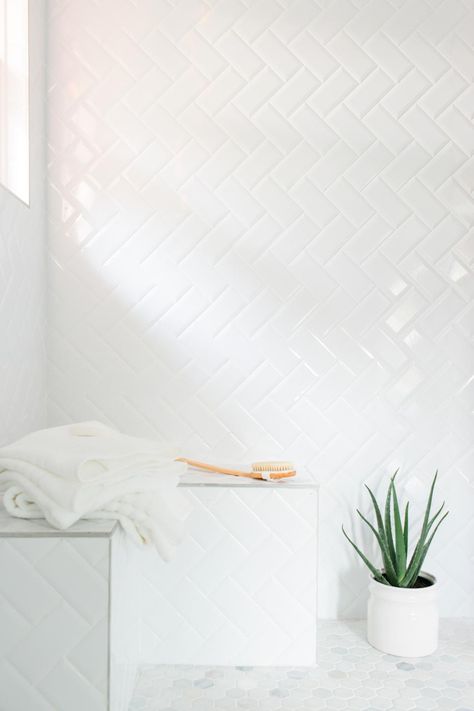 An inexpensive alternative to more pricey tiles, simple subway tiles were installed in a herringbone pattern in the shower. White grout between the tiles lends a more cohesive look. White Subway Tile Bathroom, Subway Tile Patterns, Subway Tile Showers, Modern White Bathroom, Subway Tiles Bathroom, Hgtv Dream Home, Bad Inspiration, Tile Trends, Bathroom Pictures