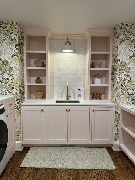 We are absolutely obsessed with this adorable and fun laundry room, featuring pastel pink cabinetry and built-ins, white tile backsplash, and a beautiful floral print wallpaper!!    New Construction | Home Trends 2024 | Home Design | Minnesota Home Trends Whimsical Laundry Room, Pink Laundry, Perfect Laundry Room, Pink Laundry Rooms, Floral Print Wallpaper, White Tile Backsplash, Minnesota Home, Construction Home, Exp Realty