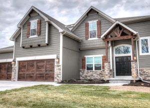 Use color and texture to create visual interest. This home in Longmont features taupe siding in two different styles along with stone accents for a custom, curated look. Taupe Vinyl Siding House, Stone And Shake Siding Exterior, Siding And Stone Exterior Color Schemes, Taupe House Exterior, Taupe Siding, Smartside Siding, Vinyl Siding House, Modern Craftsman Home, Exterior Siding Colors