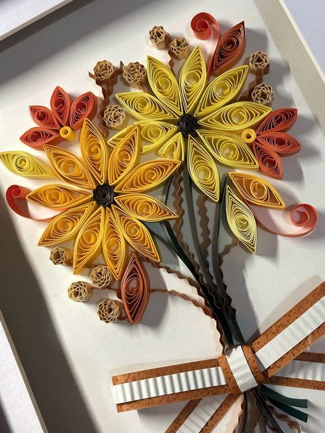 "Autumn Leaves" is a beautiful, autumn themed paper quilled artwork which consists of sunflowers and dried florals. Paper quilled art always acts as a unique gift for birthdays, holidays, anniversaries or house warming.  Each paper strip is shaped and glued to the canvas by hand, once the quilling process is complete, the piece is set into a box frame. Each artwork is packaged carefully with a thank you card and tissue paper, to complete your shopping experience with Grafika! Quilling Ideas Unique, Fall Quilling, Autumn Leaves Paper, Quiling Paper Art, Quilled Artwork, Autumn Bouquet, Quilling Ideas, Dried Florals, Paper Quilling Designs