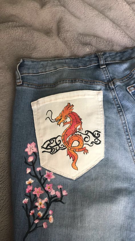 Cherry blossoms and a dragon painted on an old pair of jeans Decorate Jeans, Clothes Painting, Jean Art, Jacket Diy, Denim Diy Clothes, Clothes Embroidery, Painted Clothes Diy, Clothes Embroidery Diy, Embroidery Diy