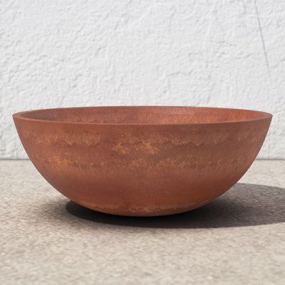 Modern minimalism meets modern design. This wide-mouthed planter pot is crafted from recycled materials, creating an accent that's both versatile enough for use throughout your home and sustainable. Crafted from a blend of composite woods and other materials, this pot features a bowl silhouette with a solid tone. It resists frost and weather, so you can use it both indoors and out. No drainage holes are included, so you don't have to worry about it leaking onto your surfaces – but we do recommen Decorative Orbs, Corten Steel Planters, Outdoor Garden Planters, Changing Table Dresser, Steel Planters, Wood Statues, Crafts From Recycled Materials, Terracotta Planter, Outdoor Pots