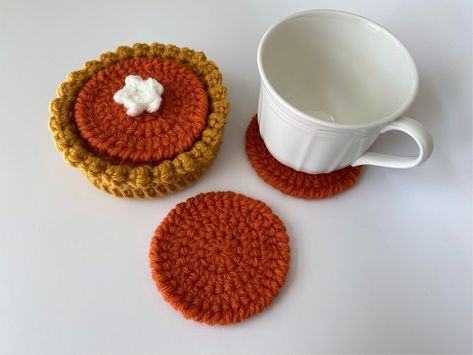 "More \"flavors\" coming soon! One of many MOD&MINIcrochet shop collectibles! This mini pumpkin pie coaster set of 5 is both delightful and functional! The bottom tart shell also acts as a coaster and holds 4 \"filling\" coasters. The top coaster has a dollop of whipped cream. The top coaster has an optional dollop of whipped cream due to whipped cream topping can make the top coaster slightly unstable when used.  When they're not in use, stack them in the tart shell and you have an adorable decoration. Perfect for home and work decor as well as birthday and holiday gifts! Size: Total height is approximately 2 inches tall. Total diameter of tart shell is approximately 4.5 inches. Diameter of \"filling\" coasters is approximately 3.5 inches. Note: These are lovingly handmade - details, colo Pumpkin Pie Crochet, Crochet Fall Coasters, Crochet Pumpkin Pie, Pie Crochet, Crochet Coaster Set, Fall Crochet Patterns, Crochet Coaster, Mini Crochet, Crochet Business