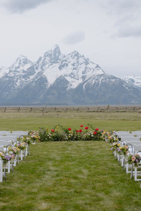 The Grand Teton Mountains lay behind a wedding ceremony with a floral ground installation and aisle of spring flowers. Simple Colorado Wedding, Montana Outdoor Wedding, Jackson Hole Wyoming Wedding Venues, Colorado Wedding Ceremony, Wedding In Glacier National Park, Wyoming Wedding Jackson Hole, Elope Jackson Hole, Banff National Park Elopement, Wedding In The Mountains Colorado