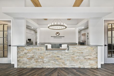 Stone, wood beam, board and batten siding and a metal accented roof make up this ground-up 3,316 sqft. dental office featuring 7 operatories. In classic Americana style, traditional, clerestory, and accent windows on the front façade establish a rectilinear visual hierarchy. Office Reception Desk Designs, Ortho Office, Chiropractic Office Design, Doctor Office Design, Waiting Room Design, Dentist Office Design, Optometry Office, Medical Office Decor, Dental Office Design Interiors