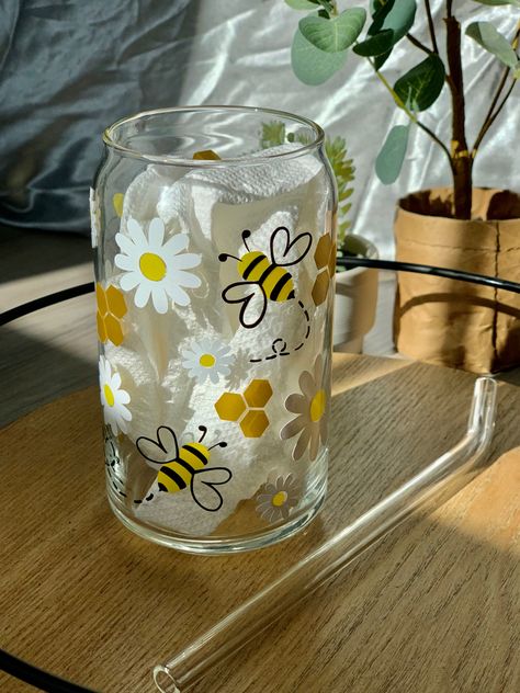 Black and yellow honey bee with white daisies and gold honey comb on a can glass. Set on a tray with a glass straw next to the glass cup and a prop tree in the background. Beer Glass Design, Glass Tumbler Design, Glass Iced Coffee Cup, Painting Glass Jars, Idee Cricut, Cute Coffee Cups, Glass Painting Designs, Diy Glass Bottle Crafts, Coffee Cup Design