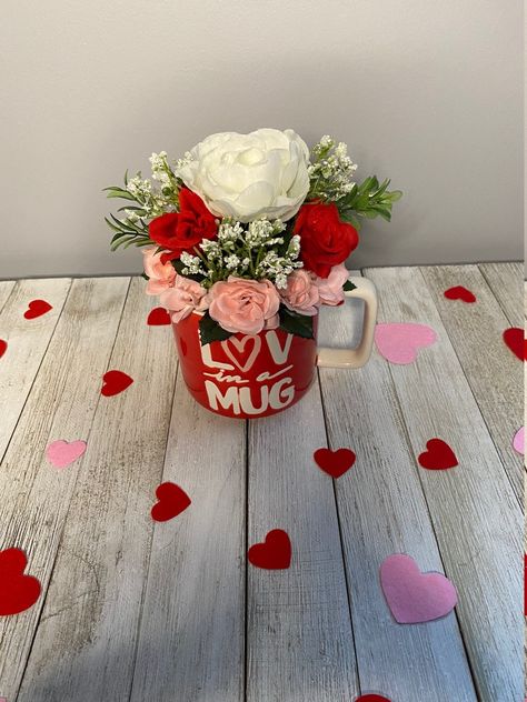 "This adorable, floral arrangement is a red mug with \"Luv in a Mug\" written in white on the front (right-handed).  It is beautifully decorated with white, red, pink silk roses, baby's breath and greens. What a cute gift this would make for your sweetheart on any special occasion...Valentine's Day, Anniversary or just I Love You. Any questions, please message me.   Each item was arranged by me, Trinity, TrinsFloralTreasures, and I enjoy every piece I create.   If you have any issue with the ite Mug Flower Arrangements, Valentine’s Day Floral Arrangements, Valentines Day Arrangements, Mug Floral Arrangement, Valentine Cups, Valentines Day Floral Arrangements, Mug With Flowers, Valentine Bouquet, Spring Arrangements