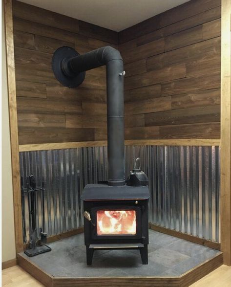 Corrugated Tin Fireplace, Snowy Cabin Aesthetic Interior, Woodstove Backdrop Ideas, Corrugated Metal Wood Stove, Coal Stove Ideas Living Rooms, Woodstoves Ideas, Metal Behind Wood Stove, Corner Pellet Stove Ideas Living Rooms, Wood Stove Surround Corner