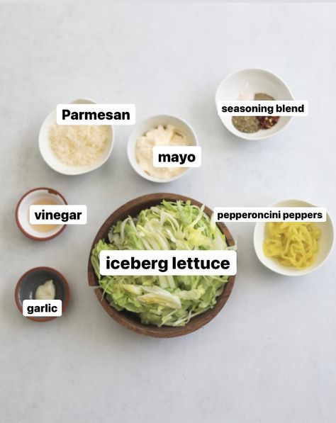 Flat lay of recipe ingredients for Italian Grinder. In small white bowls, seasoning blend, parmesan, mayo, pepperoncini peppers. In a medium sized wooden bowl is iceberg lettuce. In two small white and grey bowls is garlic and vineagar. Grinder Sandwiches Ingredients, Lettuce For Sandwiches, Grinder Lettuce Mixture, Sandwich With Chips Inside, Grinder Sauce Recipe, Grinder Salad Dressing Recipe, Grinder Dressing Recipe, Grinder Salad Recipe, Italian Grinder Salad Sandwich