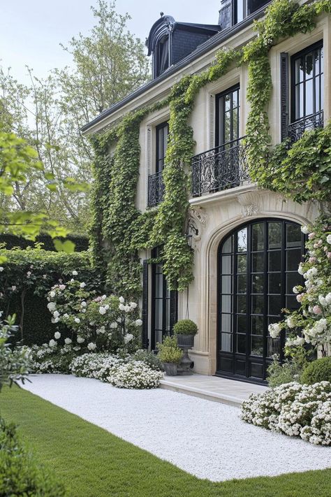 Modern french mansion courtyard facade with vine climbers fence walls with vine climbers garden with white lowers white gravel and grass. Let’s reveal the charming features, quirky details, and luxurious elegance of French mansions. White Mansion Wedding, Mansion Compound, French Modern House, French Chateau Garden, French Courtyard Garden Ideas, Modern French Mansion, Mansion Courtyard, Modern English Garden, Modern French Country Exterior