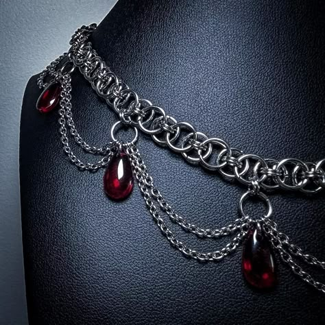 A chainmaille necklace with smaller chain detailing and red teardrop shaped beads Make Chainmail, Fantasy Villain, Villain Vibes, Chainmaille Jewelry Patterns, Chain Maille Necklace, Gothic Jewelry Diy, Chainmail Armor, Vampire Necklace, Vampire Jewelry