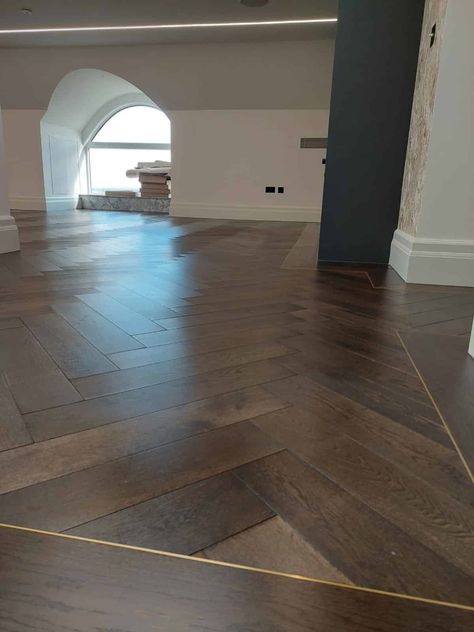 The client chose for our Istoria Bespoke Onyx to be laid throughout the first floor area of their home in Herringbone Select Grade 15/4mm x 120mm x 600mm. The flooring was complimented by antique brass trim throughout separating the 190mm border and the herringbone pattern. Istoria Bespoke Onyx is a lovely dark brown colour which is accented by a black grain and some naturally occurring highlight. Dark Herringbone Floor, Dark Brown Wood Floors, Floor Stain Colors, Wood Floor Design, Herringbone Wood Floor, Floor Stain, Oak Wood Floors, Classic Interior Design, Wide Plank