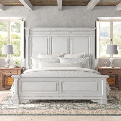 Farmhouse style meets dramatic flair in this standard bed. Crafted from solid wood with a distressed whitewash finish, this bed has the look of a piece passed down through generations. A high panel headboard shows off crown molding and picture-frame paneling, matching the footboard and low bracket feet. Built to accommodate a California king-size mattress, this bed requires a box spring (not included) and has a weight capacity of 800 lbs. It's compatible with adjustable bed bases, and includes a White Farmhouse Bed Frame, Farmhouse Bedroom Beds & Frames, Coastal Bed Frame, Farmhouse King Bed White, Arhaus Bedroom, Farmhouse Bedroom Beds & Bed Frames, Frame Paneling, Beachhouse Bedrooms Beds & Bed Frames, Boho Master