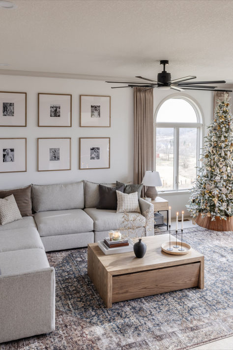 Boho neutral living room with natural lighting and Christmas tree. Grey Sectional Living Room Ideas Cozy, Grey Couch Sectional Living Room, Sectional By Fireplace, Living Room Gray Sectional Decor, Family Room Design Sectional, Small Living Room Inspirations Cozy, Stone Color Couch Living Room, Clean Farmhouse Style Living Room, Light Gray Couch Styling