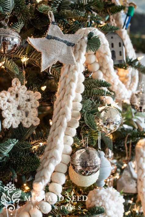 Our latest Christmas tree in our living room includes some new pieces and some old favorites: white string lights, white finger knit garland, wool pom garland, grain sack tree skirt, and vintage green hat boxes. Plus a variety of ornaments in silver, cream, blue, and gray - in textures of metal, glass, fabric, clay, papier-mache, bottle brush, and more. And, my Wallace silver Sleigh bells collection. - Miss Mustard Seed #missmustardseed #christmastree | vintage & antique holiday decor Christmas Tree Inspiration Natural, All Natural Christmas Tree Decorations, White Natural Christmas Tree, Yarn Garland Christmas, White Boho Christmas Tree, Naked Christmas Tree, Christmas Tree Decor Green, Christmas Tree Garland Diy, Boho Christmas Tree Ideas