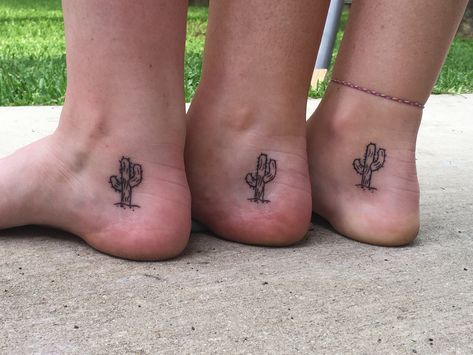 3 women’s inner ankles. There is a  saguaro cactus with some spines on it, with a line as the dirt and a couple small pebbles beneath. Small Western Ankle Tattoo, Western Sibling Tattoos, Cactus Tattoo Ankle, Dainty Cactus Tattoo, Matching Cactus Tattoos, Nopales Tattoo, Inner Foot Tattoo, Small Arizona Tattoo, Cacti Tattoos