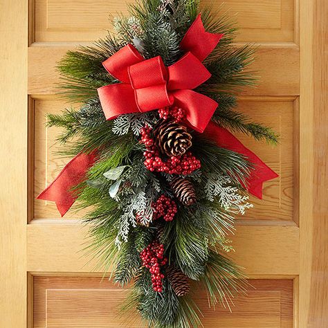 Studded with red berries and topped with a big red bow, this swag is sure to become a much-loved Christmas classic. For fullness, a long-needle teardrop-shape base anchors the holiday door arrangement. Holiday Door Decorations, Diy Christmas Door, Christmas Wreaths Diy Easy, Christmas Swag, Swag Wreath, Christmas Door Wreaths, Christmas Classic, Holiday Door, Mardi Gras Party