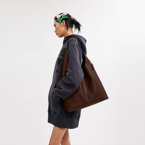 Our Brooklyn is an elegant minimalist silhouette—with a distinctly New York attitude. Crafted of natural grain leather with beautiful texture and soft feel this generously sized hobo style features a spacious interior with room for a 15” laptop and a snap pocket for access to essentials. The streamlined 39 is finished with a comfortable wide shoulder strap and an easy magnetic snap closure. | Coach Brooklyn Shoulder Bag 39 - Women's Purses - Brass/maple Coach Brooklyn Shoulder Bag Outfit, Coach Hobo Bags Outfit, Working Bag For Women, Coach Bags For Daily Use In Fall, Brown Smooth Grain Bucket Bag For Work, Coach Textured Leather Satchel For Daily Use, Modern Coach Satchel For Fall, Minimalist Textured Leather Shoulder Bag For Travel, Smooth Grain Tote Hobo Bag For Work