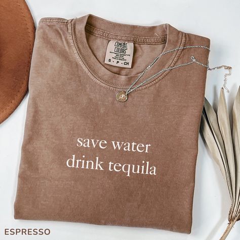 Embrace your humorous and sarcastic side with our "Save Water Drink Tequila" T-shirt. This funny and relatable design is perfect for casual outings, social events, or just relaxing at home. Crafted from premium heavy cotton, this tee offers both comfort and durability, ensuring it stands up to everyday wear. Whether it's for a casual day out, a fun gathering, or just to make a lighthearted statement, this T-shirt is a great way to showcase your personality and love for tequila. Ideal for those who appreciate witty quotes and a touch of sarcasm, this shirt is more than just apparel--it's a declaration of your fun-loving nature. 👕 PRODUCT DESCRIPTION:  Made from 100% US cotton for long-lasting comfort 🌈. Medium fabric (6.1 oz/yd² (206.8 g/m for durability 💪. Comfortable unisex fit. 👫. Tr Save Water Drink Tequila, Tequila Party, Funny Drinking Shirts, Save Water Drink, Tequila Shirt, Water Drink, Funny And Relatable, Witty Quotes, Drinking Shirts