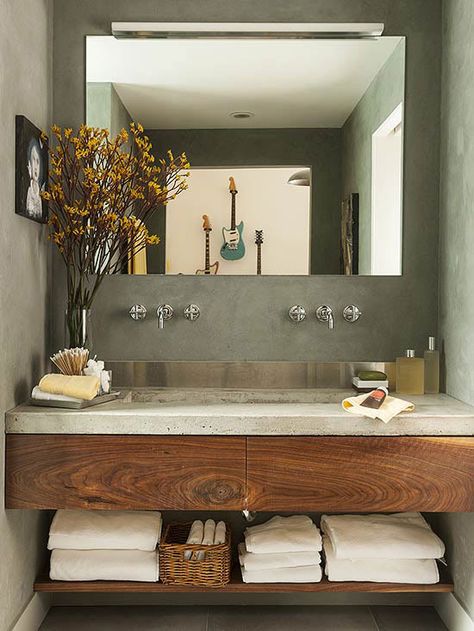 A concrete countertop and stainless-steel backsplash provide a contemporary feel to this small space. Concrete Bathroom Design, Dekorere Bad, Bilik Air, Concrete Bathroom, Bathroom Design Inspiration, Trendy Bathroom, Modern Bathroom Vanity, Bathroom Renos, House Bathroom