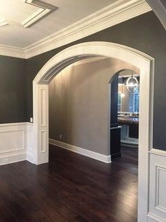 Custom trimmed cased arches with paneled jambs and paneled arched top. Adding Arches To House, Arched Cased Opening, Transitional Dining Room, Room Extensions, Wood Dining Room, Door Trims, Wood Trim, Black Walls, Sitting Room