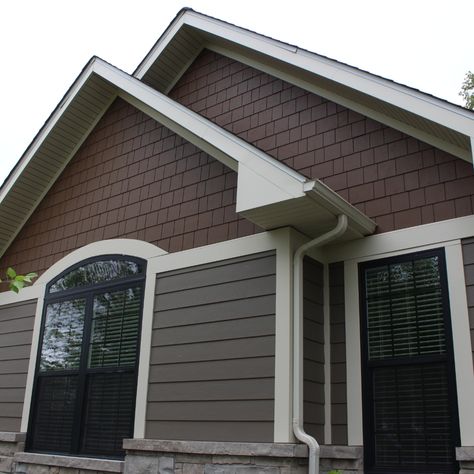 Timber Bark James Hardie lap siding was used around this house with Cobble Stone trim. The shake in the gables are custom painted to complete the beautiful look of this house. James Hardie Timber Bark Siding, Timber Bark Hardie Siding, Vinyl Siding Color Combinations, Black Trim Exterior House, Window Trim Ideas, Tudor Exterior, Vinyl Siding Colors, Siding Ideas, James Hardie Siding