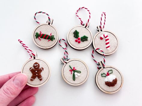 These cute mini Christmas tree decorations are hand embroidered with love and made to order. Hang on your tree, string up onto a garland, give as a stocking stuffer or advent calendar filler. Ornaments are sold individually unless 6 pack is selected. Choose from 6 cute designs or choose a pack of 6 for even greater value!  Designs include: Candy cane Gingerbread man Cracker Holly Mistletoe Christmas pudding Hoop size 4 x 4 cm, depth 0.6 cm, measurement from top to bottom of the hoop 4.8 cm Each Christmas Embroidery Ornaments, Diy Easy Embroidery, Festive Embroidery, Embroidery Christmas Ornaments, Mini Christmas Tree Decorations, Christmas Hand Embroidery, Advent Calendar Fillers, Embroidered Tree, Embroidery Decor