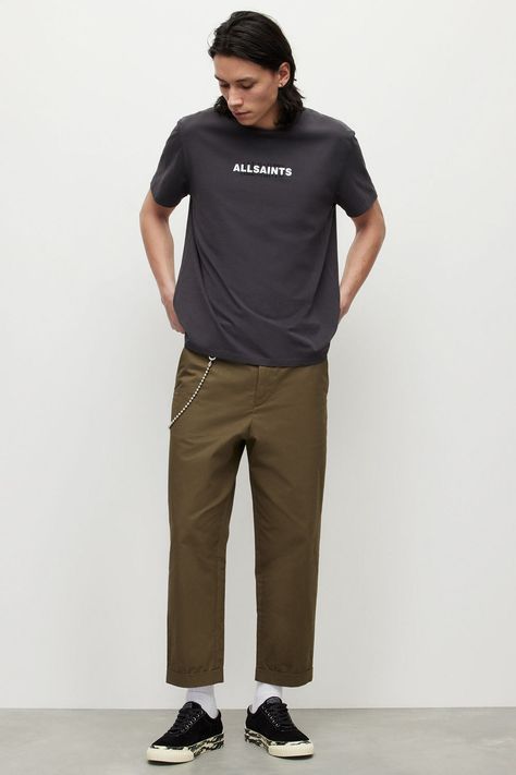 Men's khaki green cropped wide-leg chinos, black logo T-shirt, white socks, black canvas sneakers and wallet chain outfit. This outfit was included in the article: How To Wear Wide-Leg Pants: 20 Outfits That Won’t Make You Look Like A Clown, on MensFlair.com Wallet Chain Outfit, Cropped Trousers Outfit, Wide Pants Outfit, Trousers Outfit Men, Cropped Pants Outfit, Black Canvas Sneakers, Chain Outfit, 20 Outfits, Brand Personality